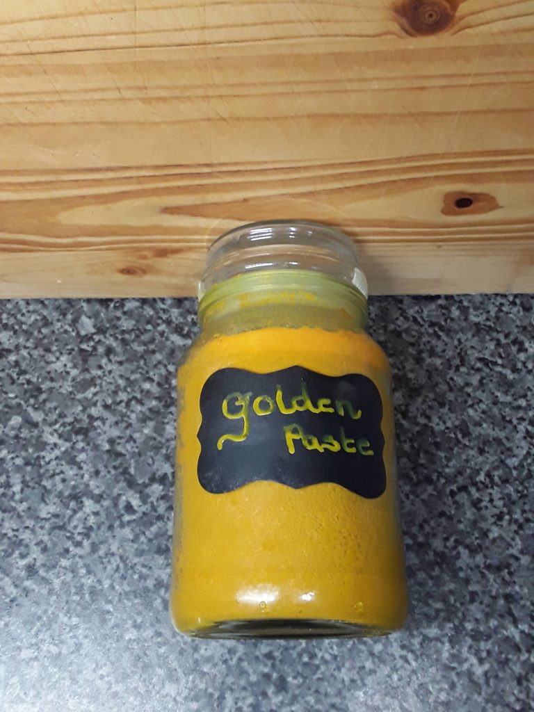 Jar of golden paste for curcumin benefits